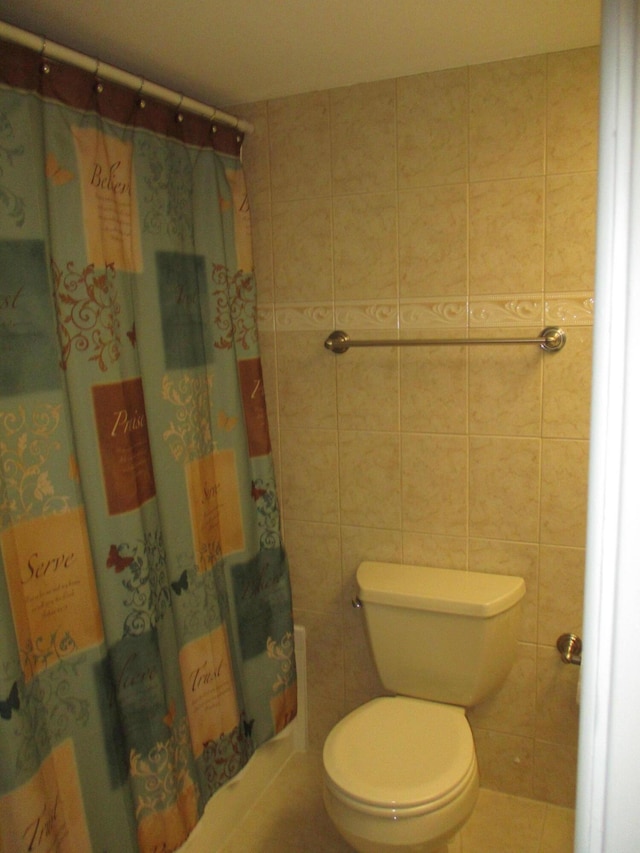 bathroom with a shower with shower curtain, tile walls, and toilet