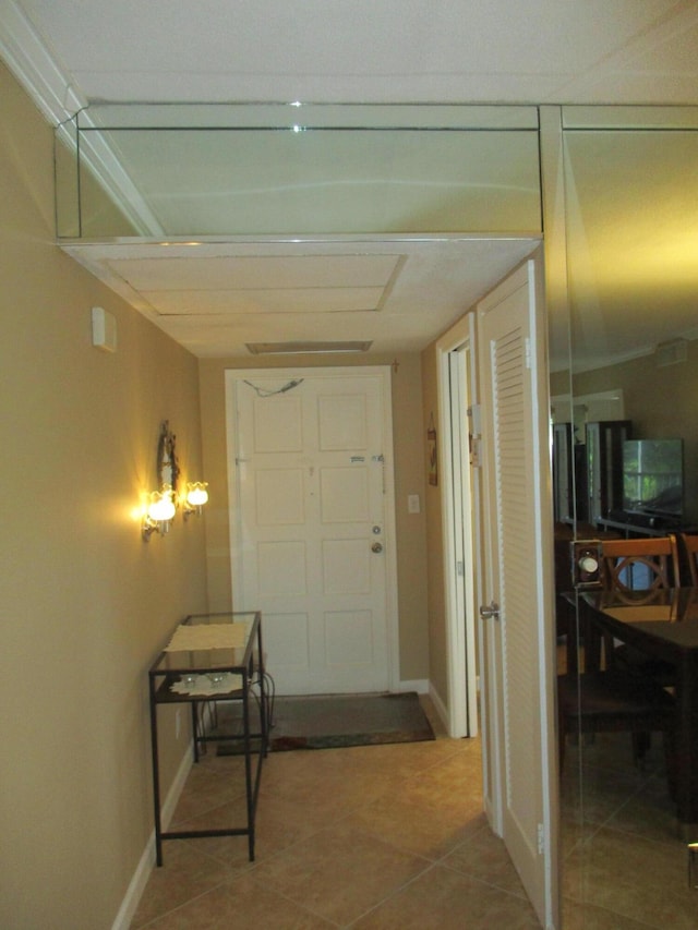 hallway with baseboards and tile patterned floors