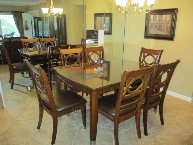 dining area featuring a chandelier, light tile patterned flooring, and baseboards