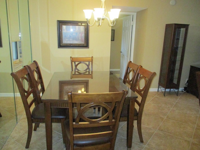 dining area with light tile patterned floors, baseboards, and a notable chandelier