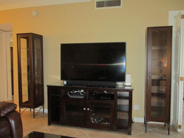 living room with baseboards, light tile patterned flooring, visible vents, and crown molding