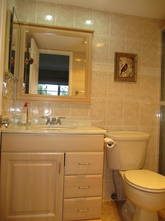 bathroom featuring decorative backsplash, toilet, tile patterned floors, vanity, and tile walls