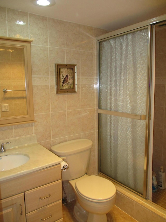 full bathroom with tile walls, decorative backsplash, toilet, a stall shower, and vanity