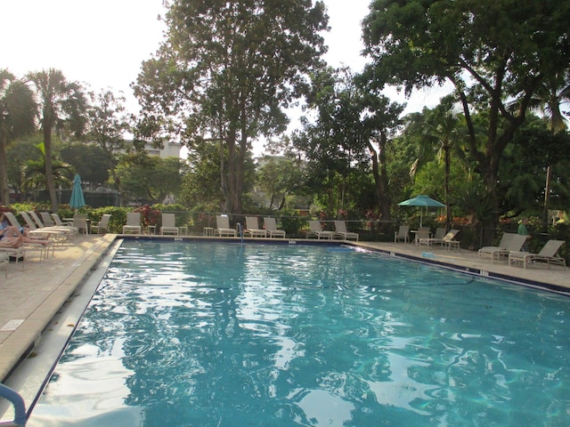 community pool with a patio area and fence