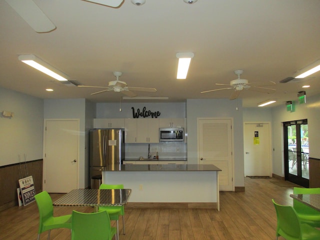 kitchen featuring stainless steel appliances, white cabinets, french doors, light wood-type flooring, and dark countertops