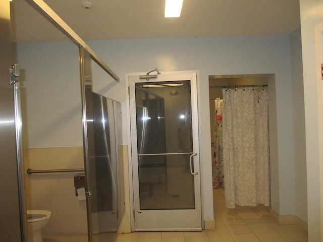 bathroom featuring toilet, a shower with curtain, and tile patterned floors