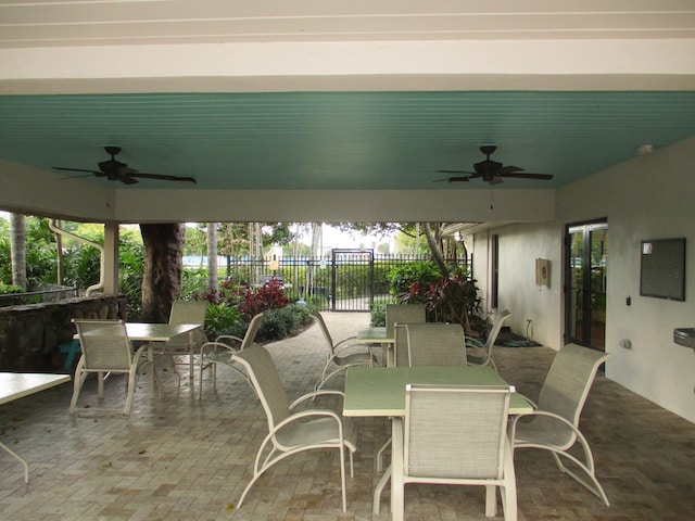 view of patio featuring fence, outdoor dining area, a ceiling fan, and french doors