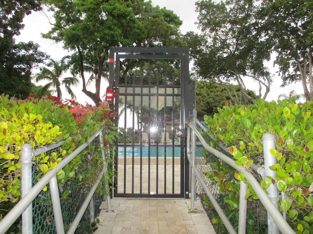 view of gate featuring fence and an outdoor pool