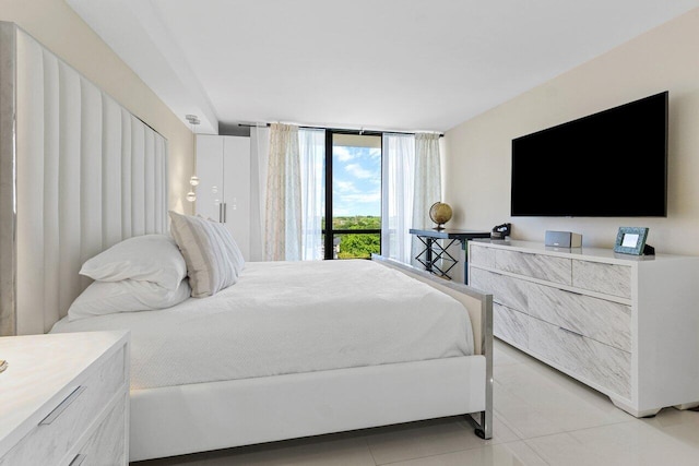 bedroom with expansive windows and light tile patterned floors