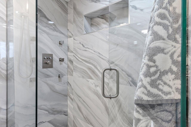 interior details featuring a marble finish shower