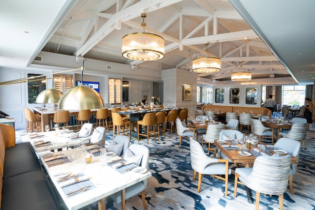 dining room featuring high vaulted ceiling, beamed ceiling, and visible vents