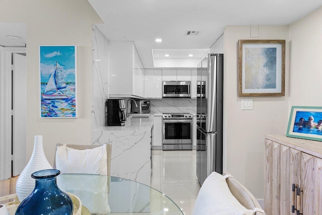 kitchen featuring visible vents, modern cabinets, appliances with stainless steel finishes, light countertops, and white cabinetry