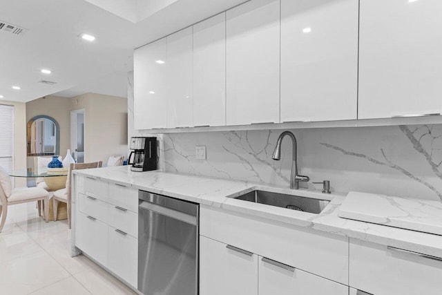 kitchen featuring visible vents, modern cabinets, stainless steel dishwasher, white cabinetry, and a sink