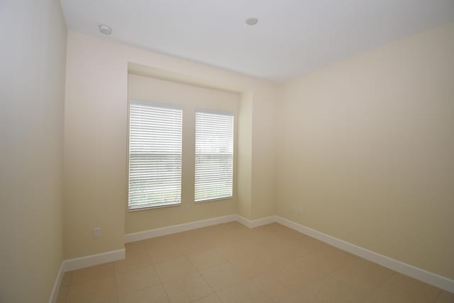 unfurnished room with baseboards