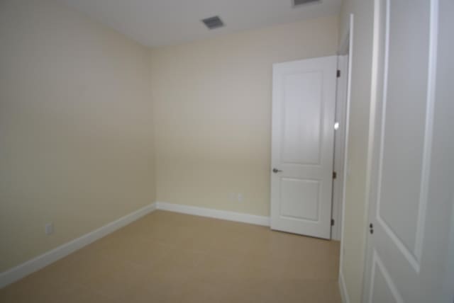 spare room featuring visible vents and baseboards