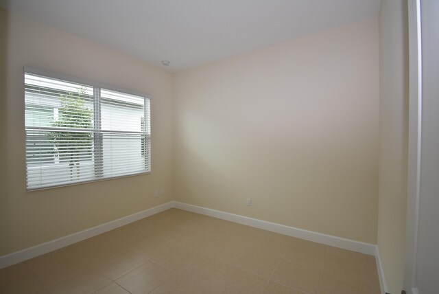 unfurnished room with baseboards