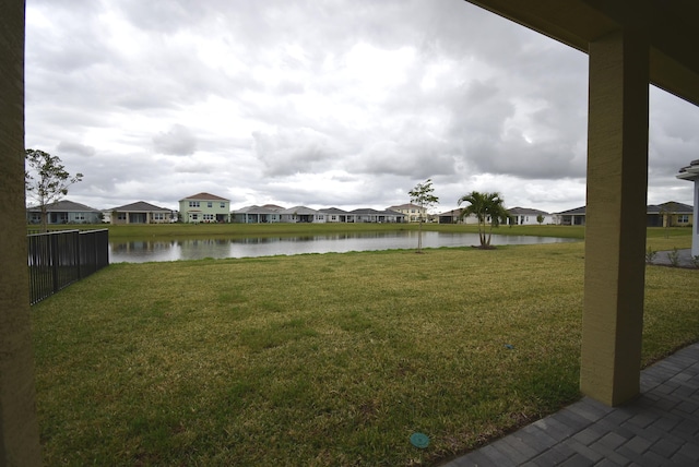 view of yard with a residential view and a water view