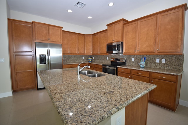 kitchen featuring appliances with stainless steel finishes, a sink, visible vents, and decorative backsplash