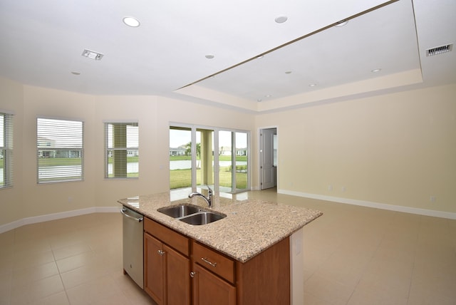 kitchen with a tray ceiling, open floor plan, and stainless steel dishwasher