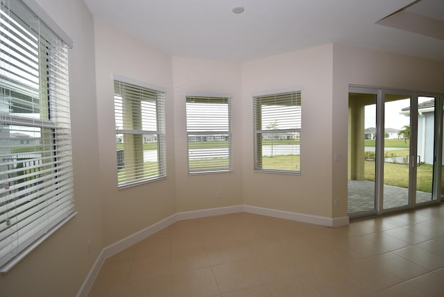 unfurnished room featuring tile patterned flooring and baseboards