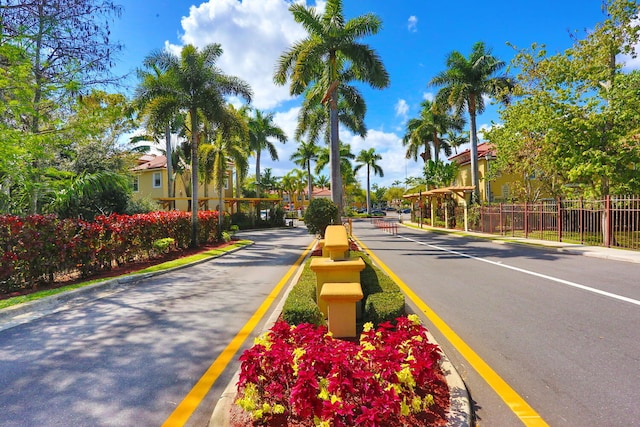 view of street featuring a gated entry and curbs