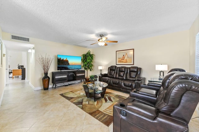 living area with light tile patterned floors, a ceiling fan, baseboards, visible vents, and a textured ceiling