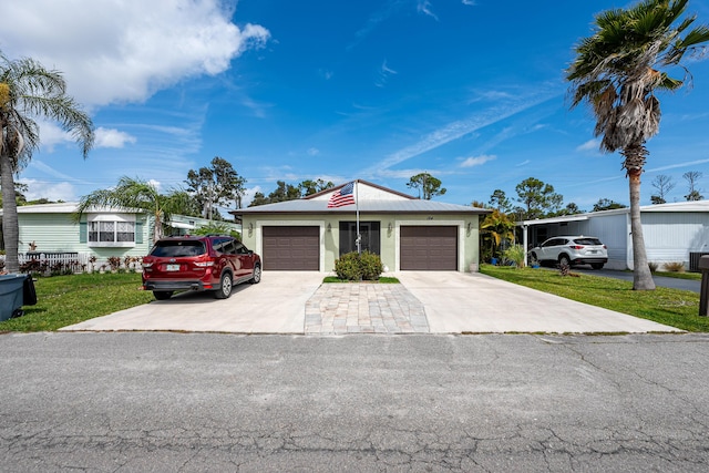 mid-century home featuring concrete driveway, a front lawn, and an attached garage