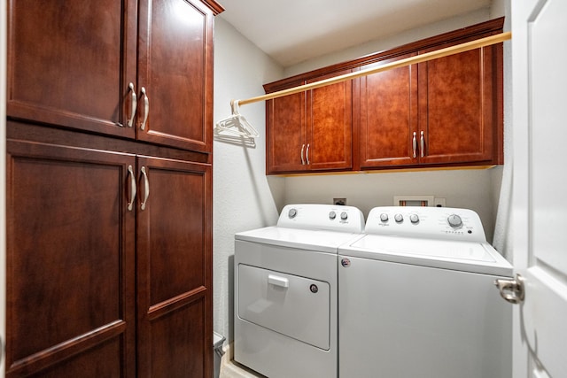 washroom with cabinet space and washer and clothes dryer