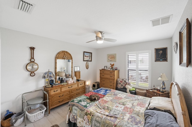 bedroom with light wood-style floors, visible vents, and ceiling fan