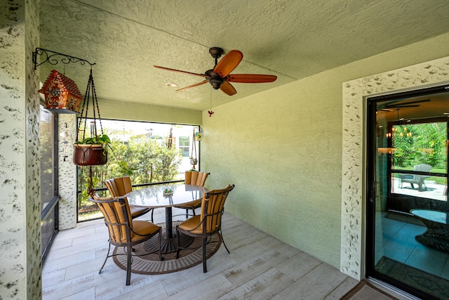 sunroom / solarium featuring a ceiling fan