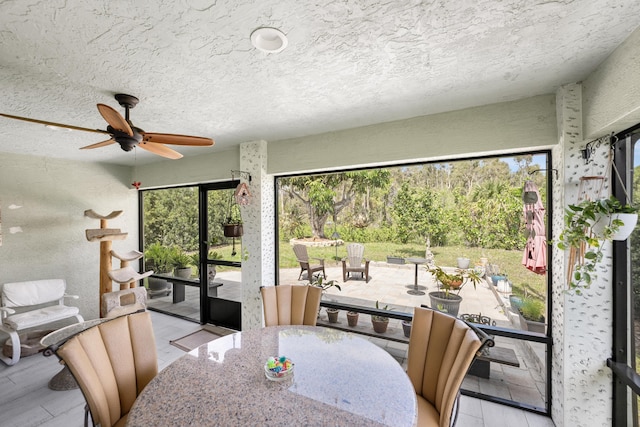 dining area with a textured ceiling, light wood finished floors, and a ceiling fan