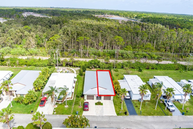 drone / aerial view featuring a forest view and a residential view