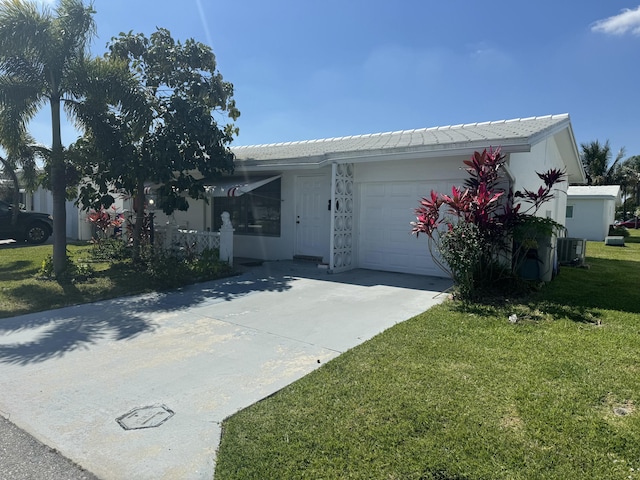 ranch-style home featuring a garage, concrete driveway, central AC, and a front lawn