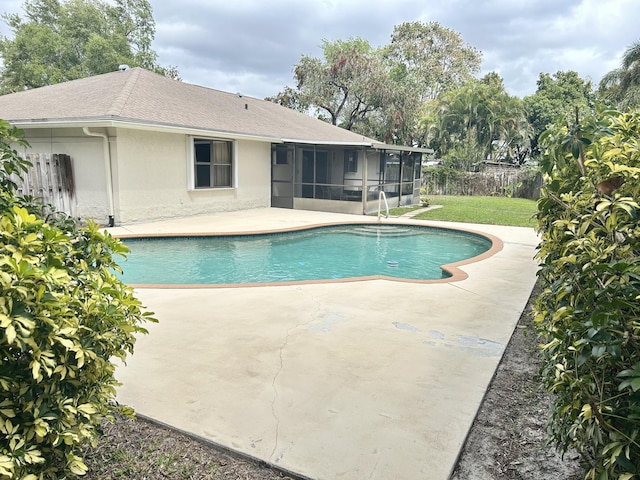 view of swimming pool featuring a patio, fence, a sunroom, a lawn, and a fenced in pool