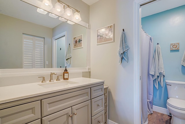 full bathroom with a shower with curtain, toilet, wood finished floors, baseboards, and vanity