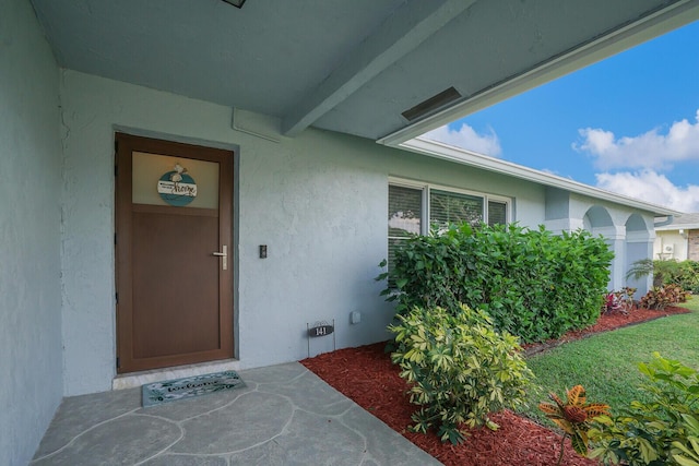 property entrance with stucco siding