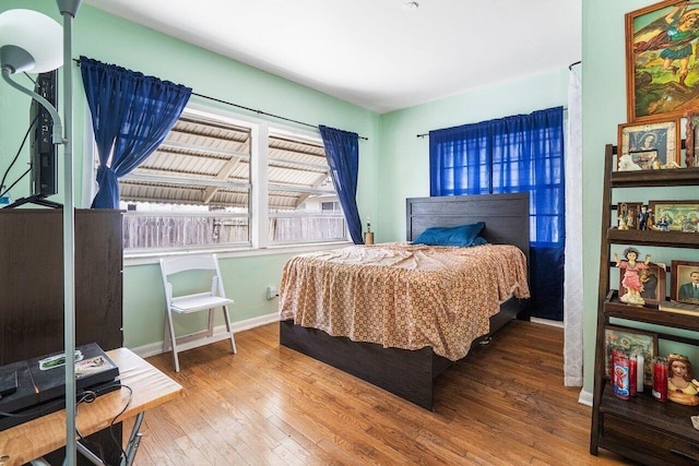 bedroom with baseboards and hardwood / wood-style flooring