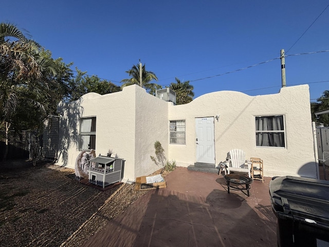 back of property with a patio and stucco siding