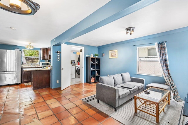 living room with light tile patterned flooring and separate washer and dryer