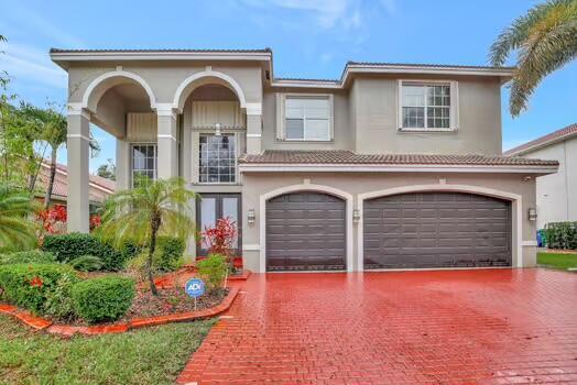 view of front of home with a tiled roof, decorative driveway, and stucco siding