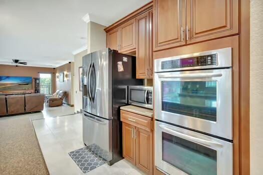 kitchen with appliances with stainless steel finishes, open floor plan, and light countertops