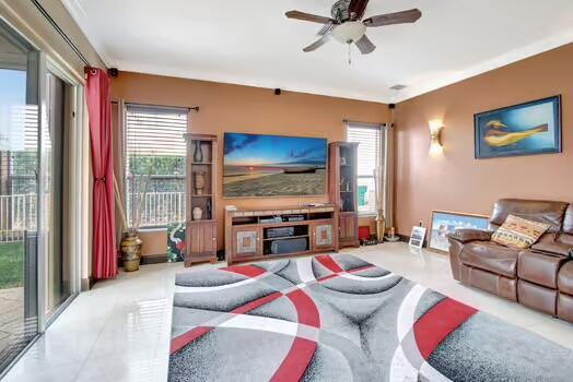 living area with a ceiling fan and baseboards