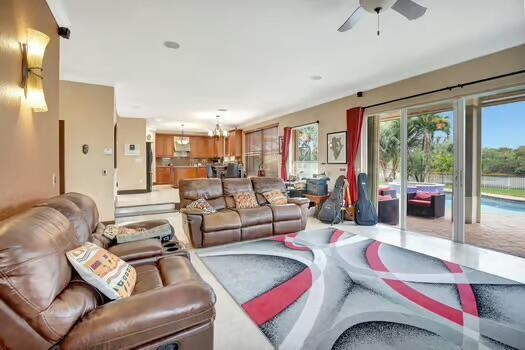 living room with ceiling fan with notable chandelier