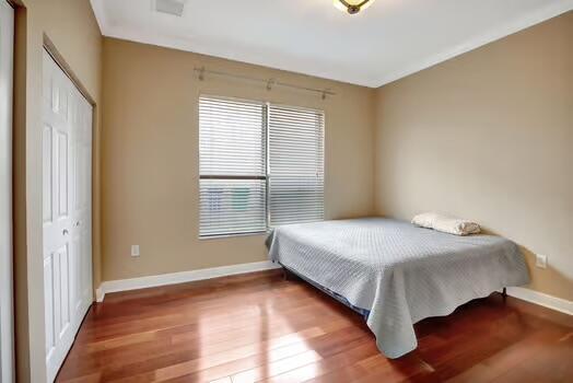 bedroom featuring a closet, baseboards, and wood finished floors