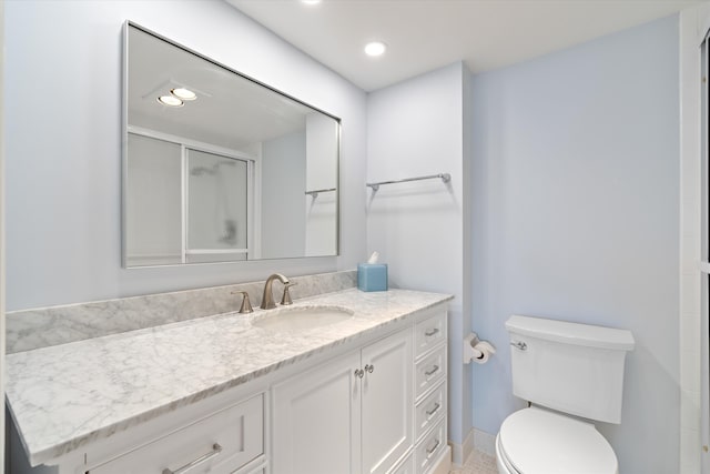 full bath featuring a stall shower, vanity, toilet, and recessed lighting