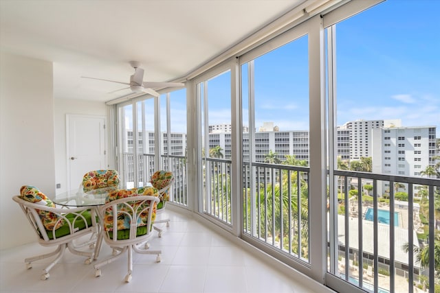 sunroom / solarium with ceiling fan and a view of city