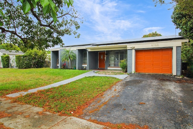 mid-century modern home featuring a garage, driveway, a front lawn, and solar panels