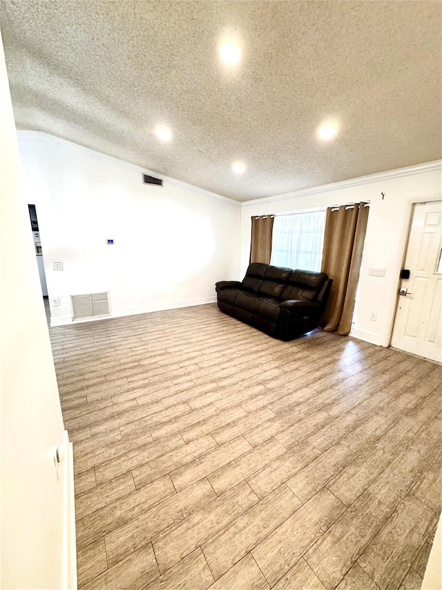 living room with a textured ceiling, visible vents, and wood finished floors