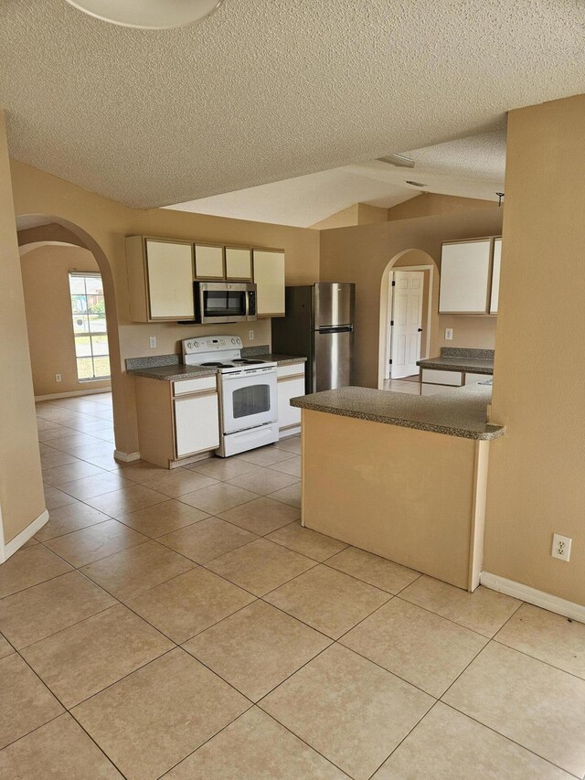 570 Ontario St NW, Palm Bay, FL 32907 - kitchen featuring appliances with stainless steel finishes, arched walkways, a textured ceiling, dark countertops, and light tile patterned flooring