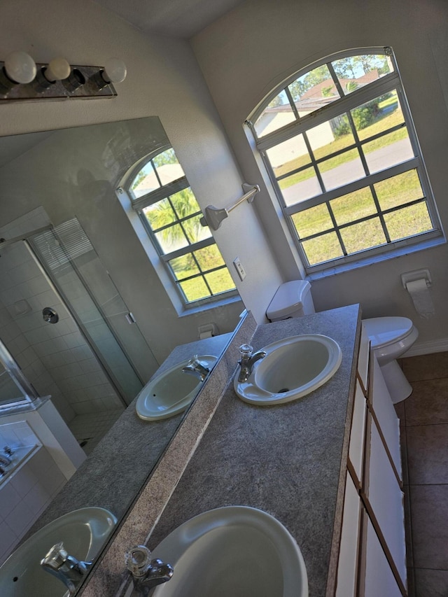 570 Ontario St NW, Palm Bay, FL 32907 - bathroom featuring double vanity, healthy amount of natural light, a stall shower, and tile patterned flooring